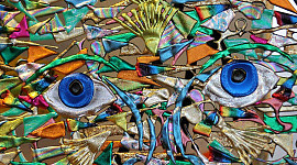 obra de arte abstracta de una cara con dos ojos de platillo azul