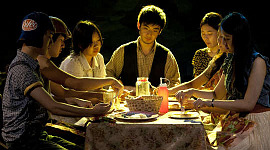 un groupe de personnes assises autour d'une table partageant un repas