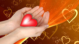 sayısız kalpten oluşan arka planda parlayan bir kalbi tutan eller
