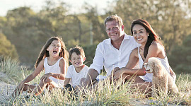 una familia alegre sentada afuera en un prado