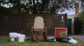 een oude schommelstoel die buiten zit om het huisvuil op te halen