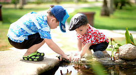 两个小男孩在池塘边玩耍