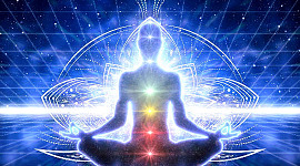 en person i meditation med oplyste chakraer og energilinjer rundt i kroppen