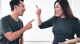 ett par som bråkar och pekar fingrar åt varandra