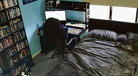 침대 머리 바로 옆에 컴퓨터와 책상이 있는 침실