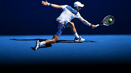 ahtlete slår en boll med en racket i Australian Open