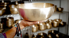 mani che reggono una grande campana tibetana