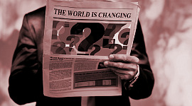 seorang pria membaca koran dengan tajuk "Dunia sedang Berubah"