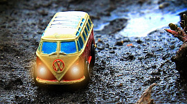 furgoneta Volkswagen amarilla en un terreno montañoso húmedo