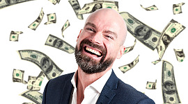 um homem sorridente com dinheiro caindo do céu ao seu redor