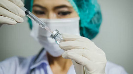 verpleegster die een naald voorbereidt voor vaccinatie