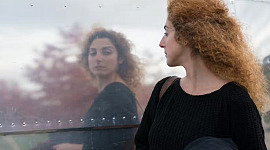Eine Frau überprüft ihr Spiegelbild, während sie vorbeigeht