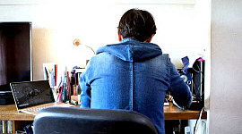 спина человека, сидящего за столом