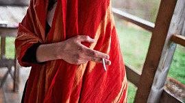 ang taong naka-red shawl ay may hawak na sigarilyo