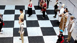 шахматная доска с людьми в качестве шахматных фигур