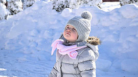 دختر جوان در زمستان که به آسمان نگاه می کند